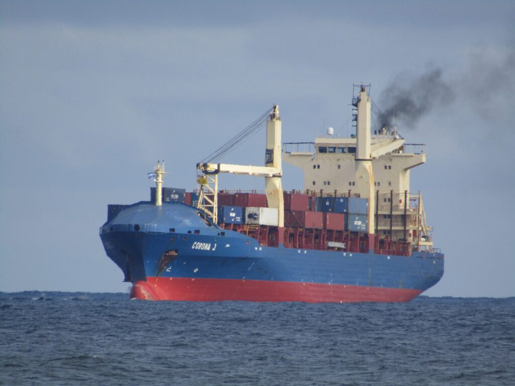 Greek coast guard vessel approaches a distressed cargo ship in rough seas near Lesbos island