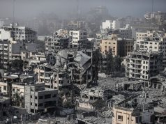 Gaza War Kills 75,811 People gathered near a damaged building in Gaza, surveying the aftermath of an airstrike