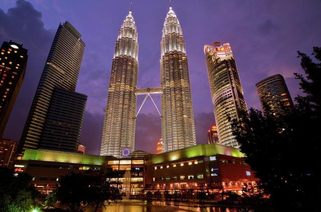 Petronas Twin Towers Kuala Lumpur Activists hold banners outside EPF headquarters demanding divestment from coal plants visible in background.